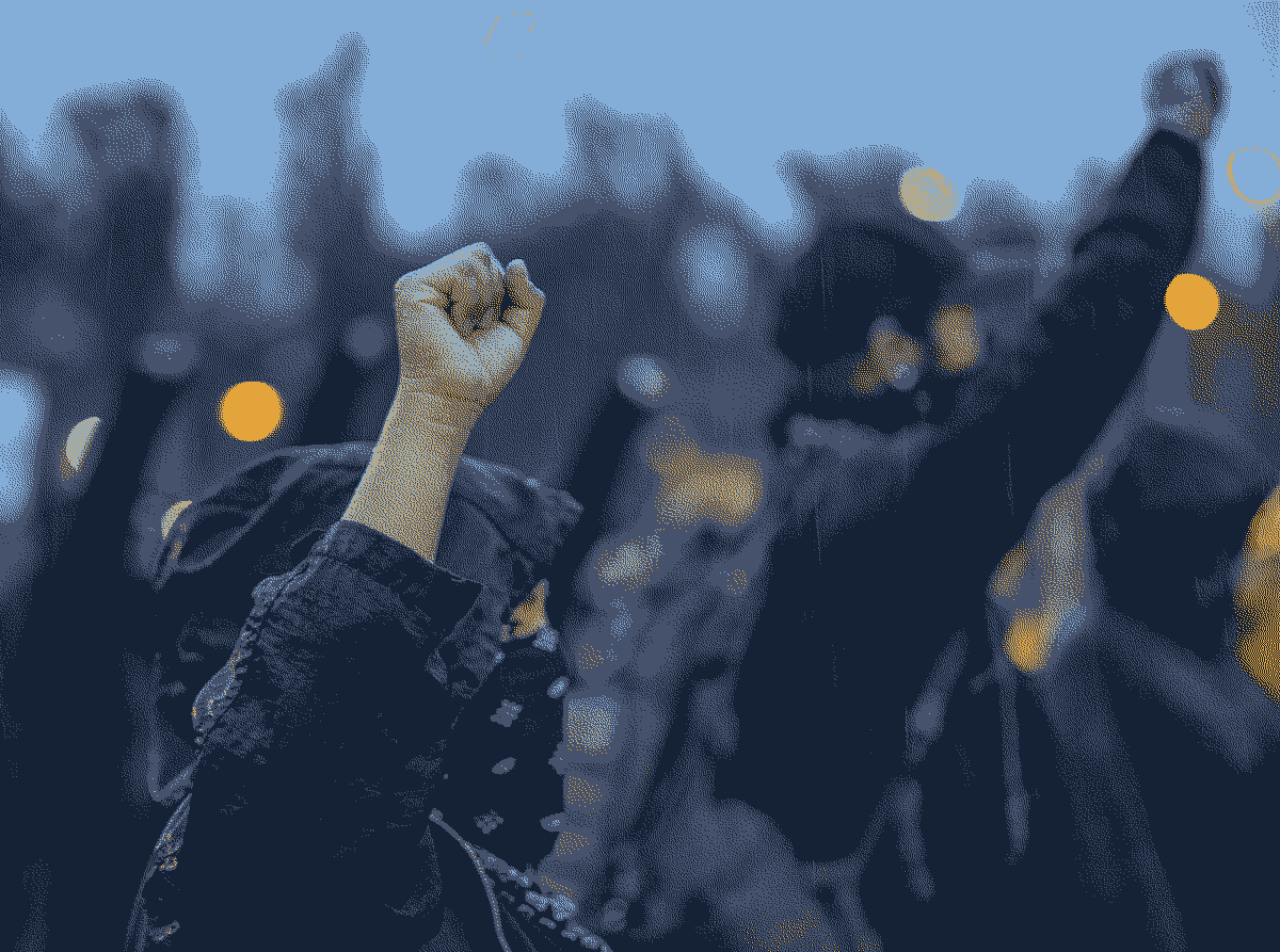 Two people wearing masks with their fists in the air.