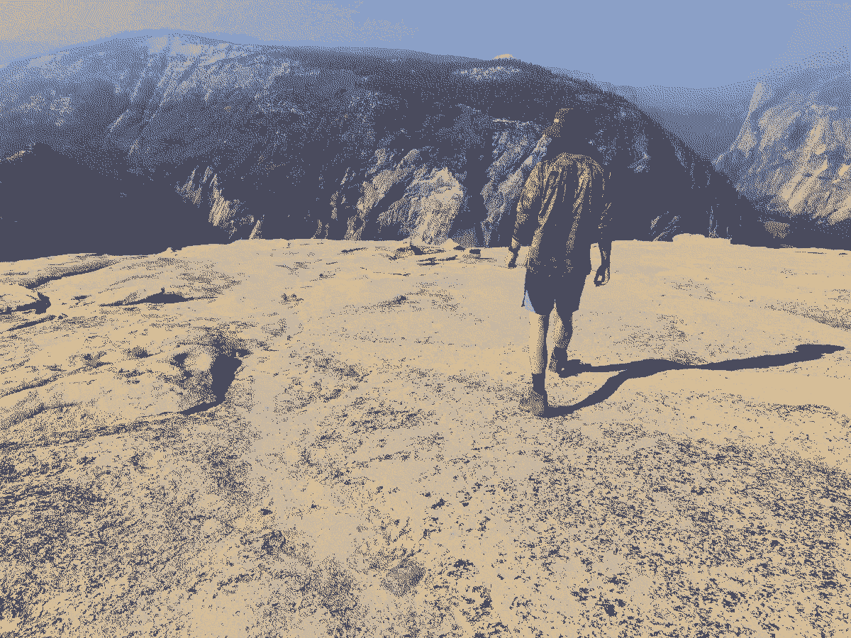 A stranger I met on top of Half Dome walking toward the edge to show me a climbing route.